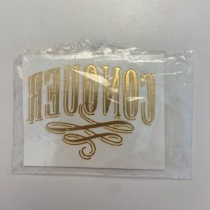 Tattly Conquer tattoo